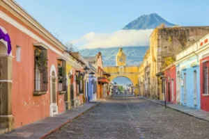 Street scene with St. Catherine's Arch in Antigua Guatemala, with Volcán de Fuego in background